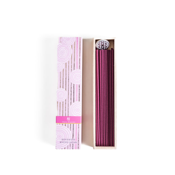 Elegant Sakura Incense in a light wooden box with soft pink sticks, elegantly packaged in a delicate pink design featuring white circular patterns, evoking the gentle aroma of cherry blossoms.