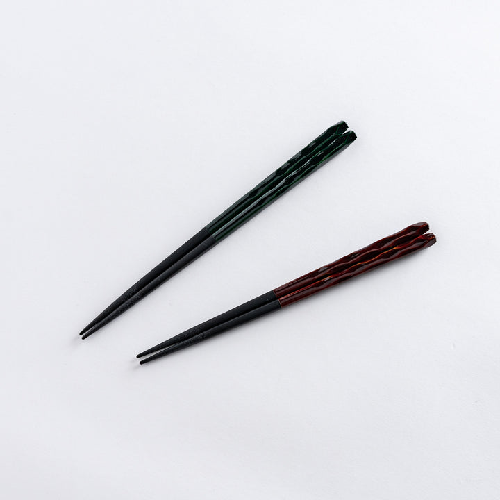 Two chopsticks with intricate carvings, displayed side by side.