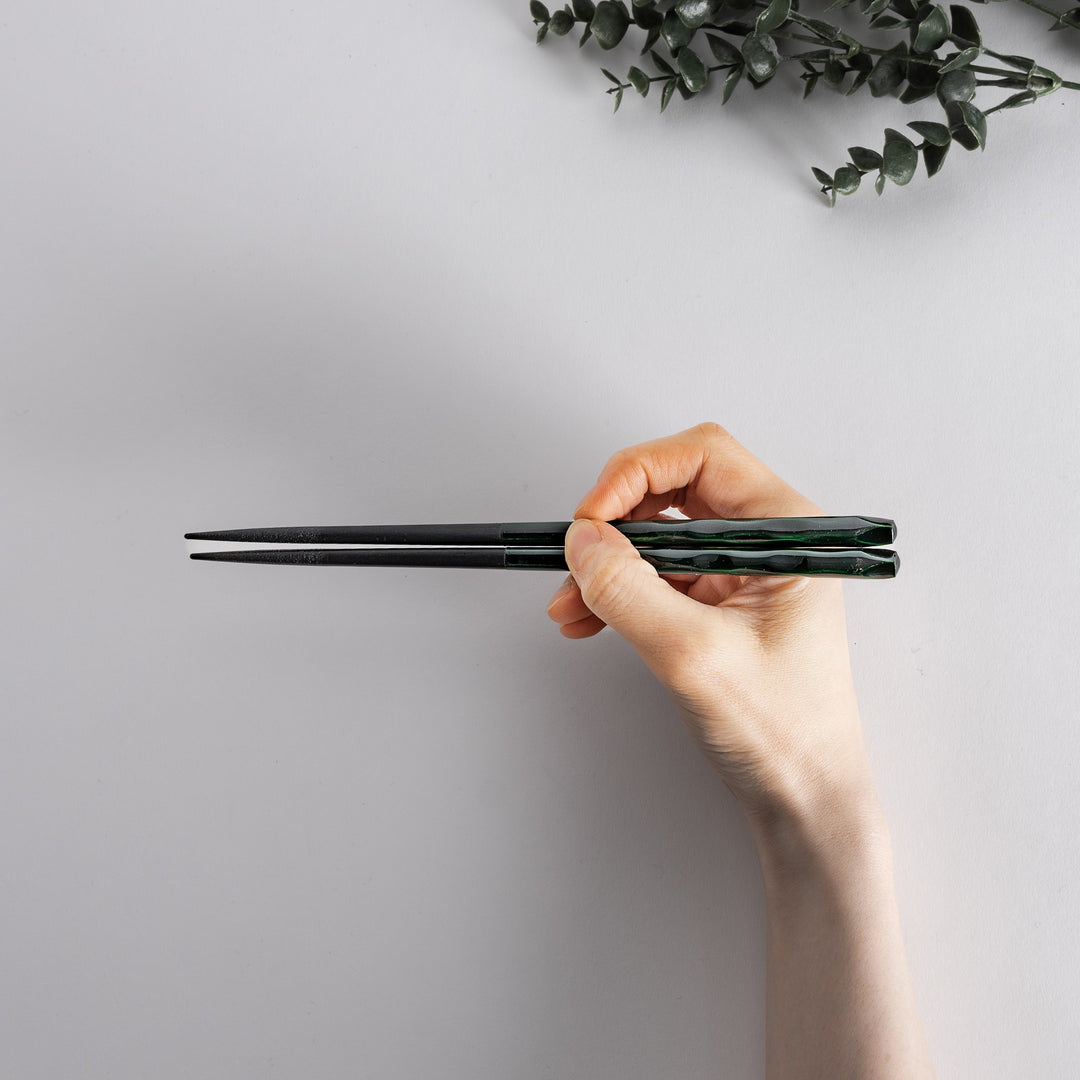 Forest color chopstick held in hand, highlighting the intricate forest pattern.