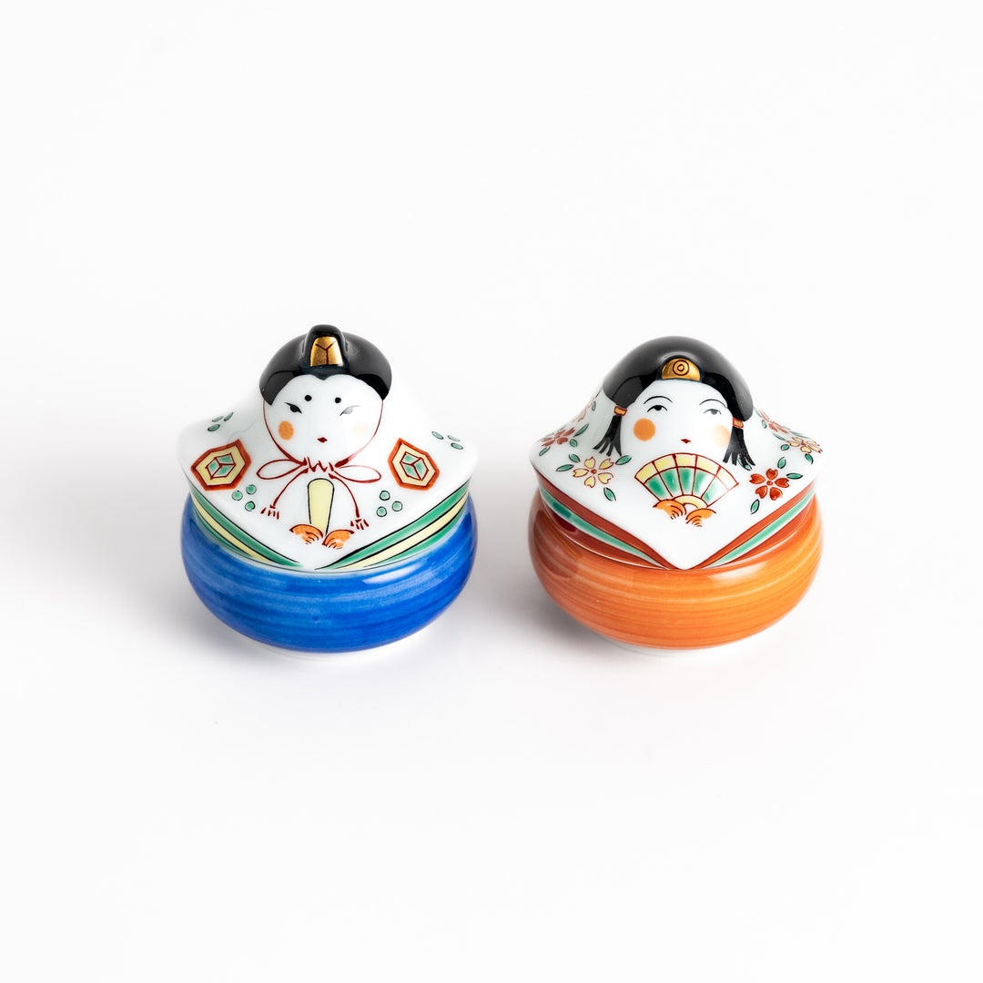 Two ceramic condiment bowls with charming traditional Japanese doll designs, perfect for serving small portions of spices, sauces, or snacks with a festive touch.