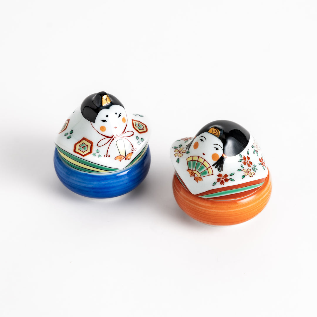 Two ceramic condiment bowls with charming traditional Japanese doll designs, perfect for serving small portions of spices, sauces, or snacks with a festive touch.