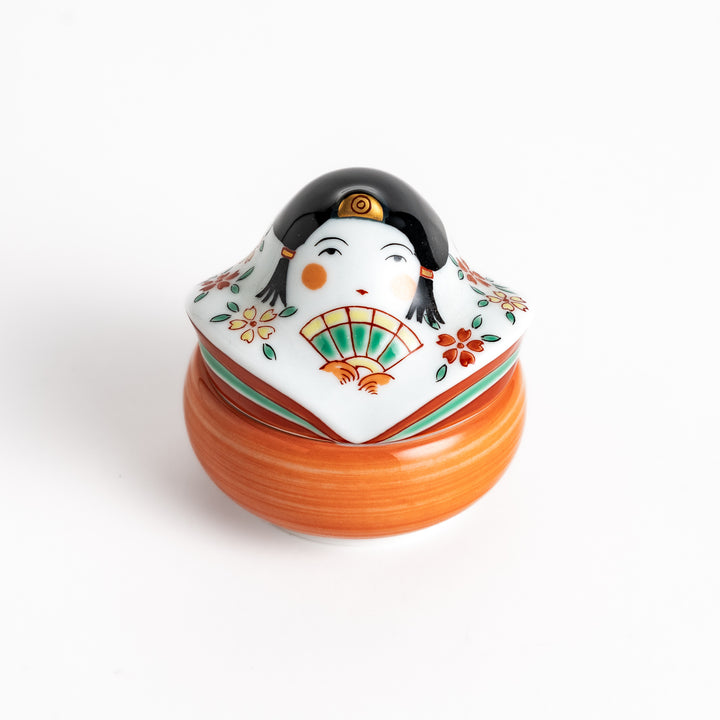 Orange and white ceramic condiment bowl with a charming Japanese doll design, perfect for adding a touch of whimsy to your table setting.