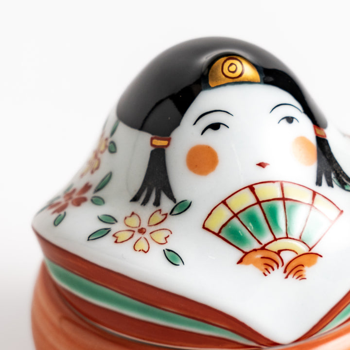 Orange and white ceramic condiment bowl with a charming Japanese doll design, perfect for adding a touch of whimsy to your table setting.