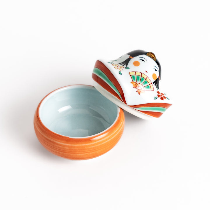 Orange and white ceramic condiment bowl with a charming Japanese doll design, perfect for adding a touch of whimsy to your table setting.