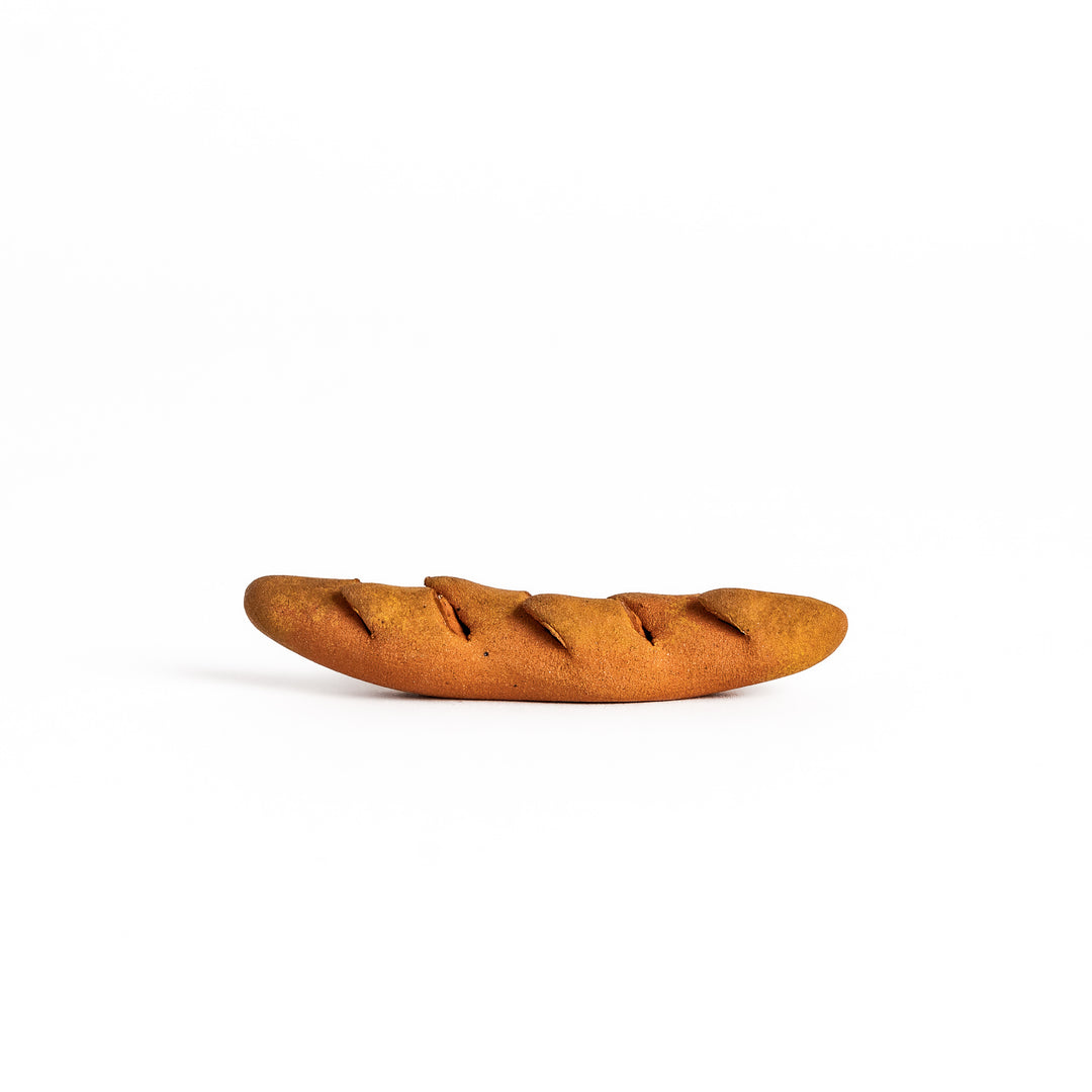 Epi Bread Chopstick Rest shaped like a baguette with intricate details and a warm brown finish, perfect for adding charm to your table setting.