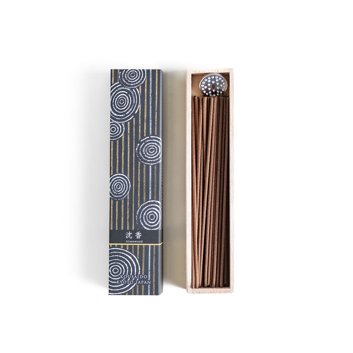 Ethereal Agarwood Incense in a light wooden box with warm brown sticks, elegantly packaged in a deep black design featuring white circular patterns, evoking a rich and meditative agarwood aroma.