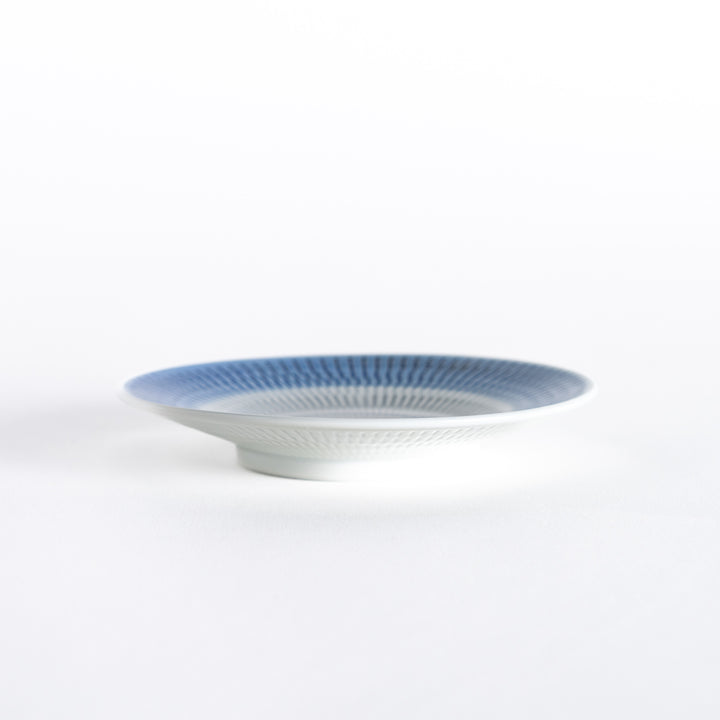 Side view of the blue dessert plate, displaying its sleek profile and rounded edges.