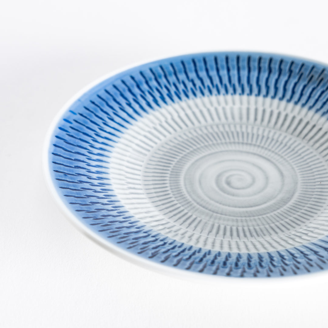 Close-up of the blue dessert plate, highlighting its detailed spiral-striped design.