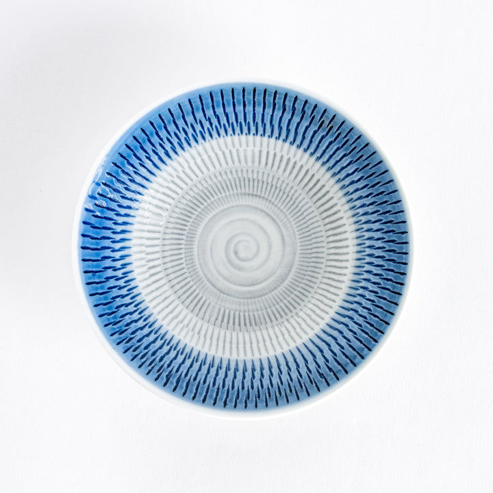 A blue dessert plate with bold radiating spiral-striped patterns, captured from the front.