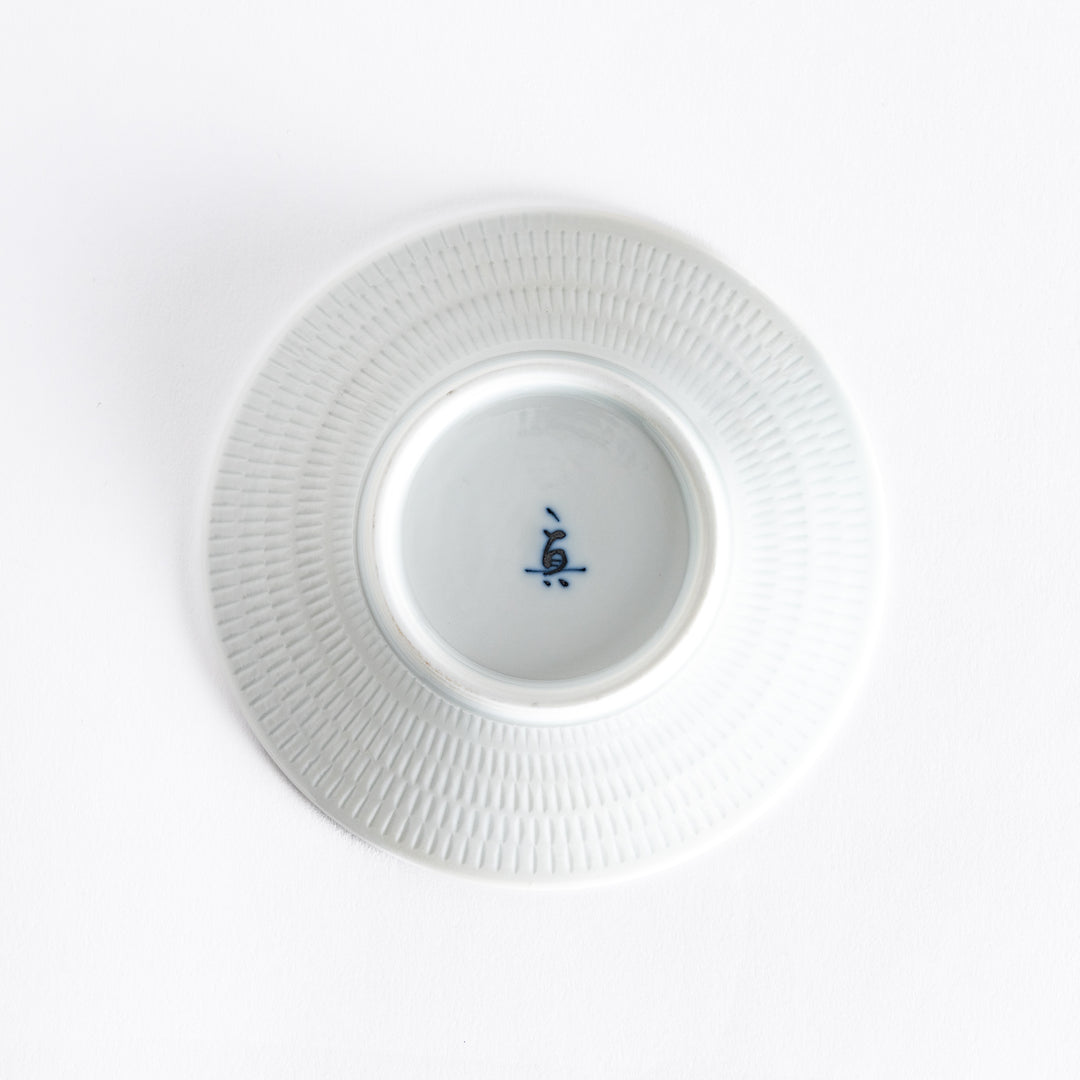 The bottom of the blue dessert plate, featuring a white smooth base with a delicate finish.