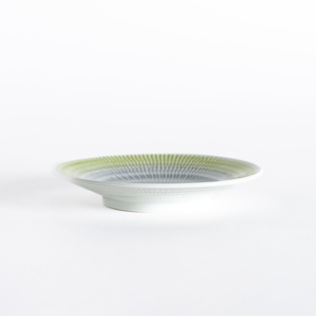 Side view of the yellow-green dessert plate, showing its curved shape and smooth edges.