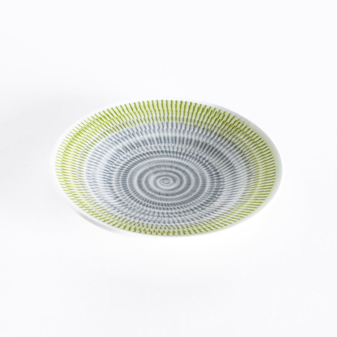 Yellow-green dessert plate with elegant spiral-striped patterns, photographed at an angle.