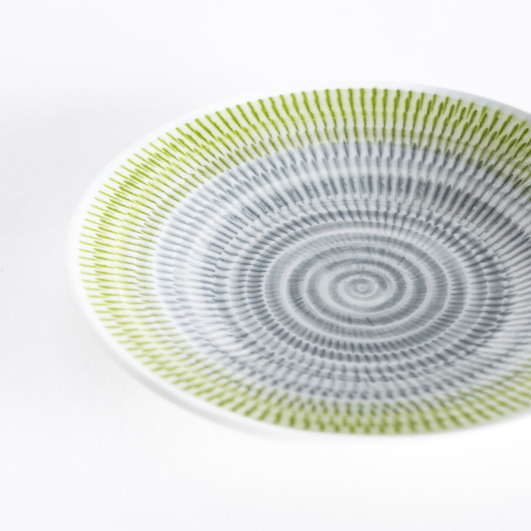 Close-up of the yellow-green dessert plate’s intricate spiral-striped pattern.