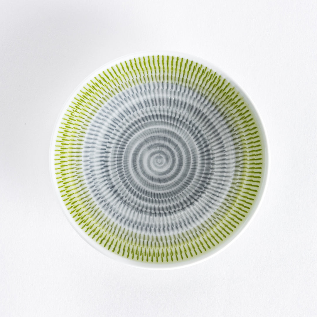 A yellow-green dessert plate with soft radiating spiral-striped patterns, viewed from the front.