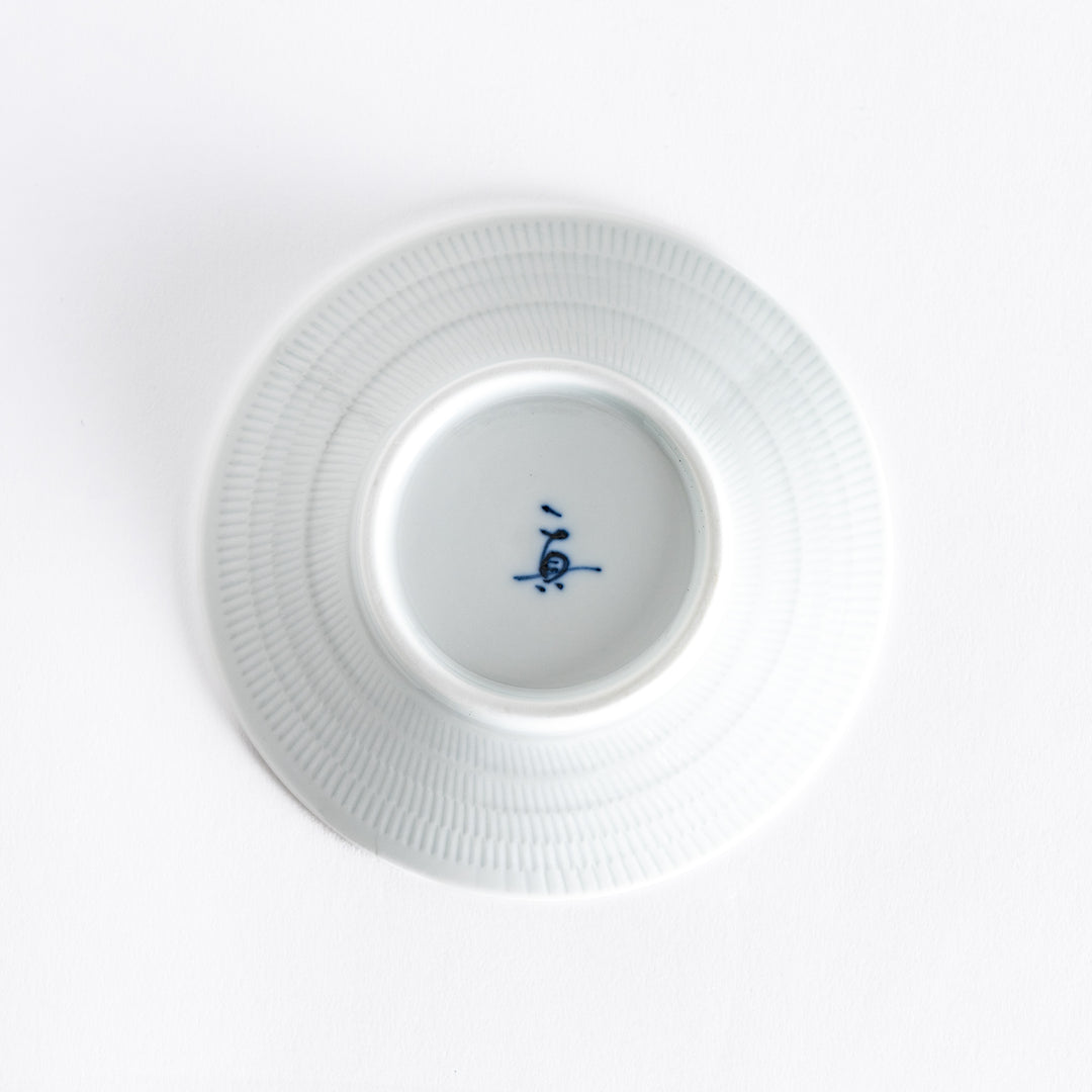 The bottom of the yellow-green dessert plate, featuring a smooth white surface and subtle base.