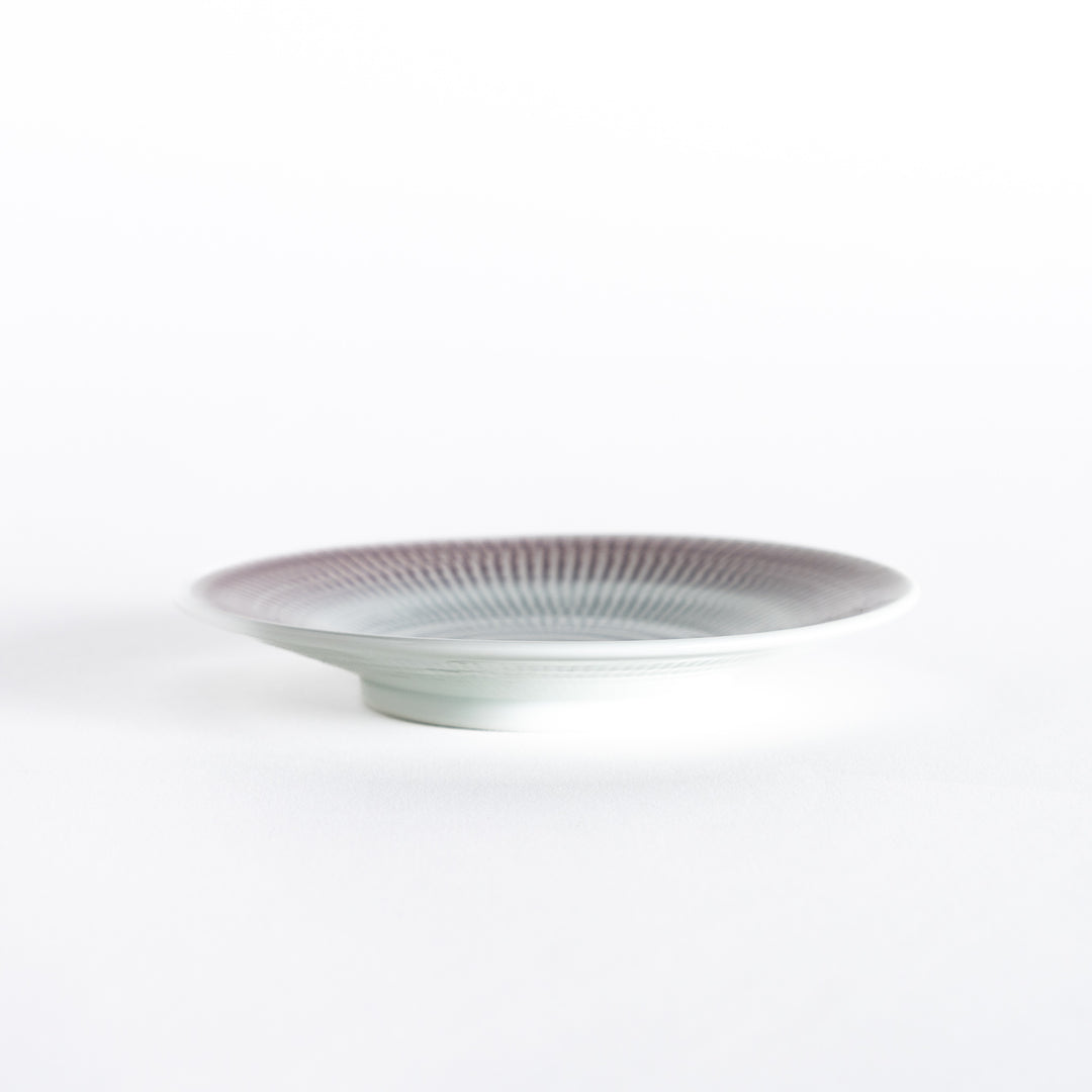 Side view of the light purple dessert plate, highlighting its smooth curve and clean edges.