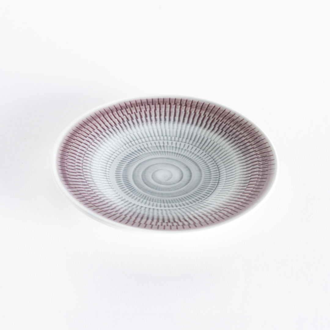 Light purple dessert plate with elegant spiral-striped patterns, photographed from a slight angle.