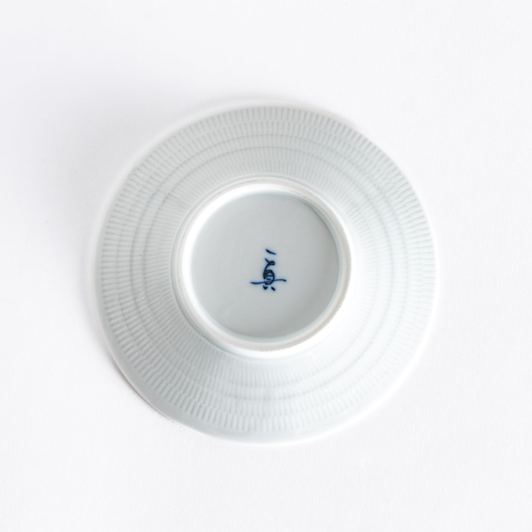 The bottom of the light purple dessert plate, featuring a smooth white base with a subtle rim.