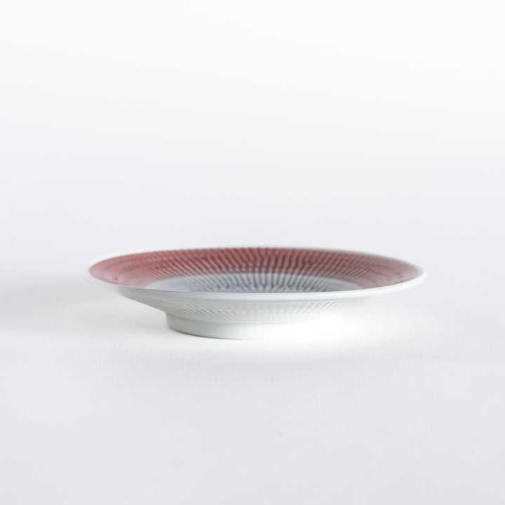 Side view of the red dessert plate, emphasizing its elegant curvature and polished edges.