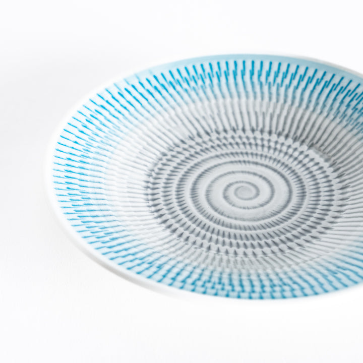 Close-up of the light blue dessert plate’s detailed spiral-striped pattern.