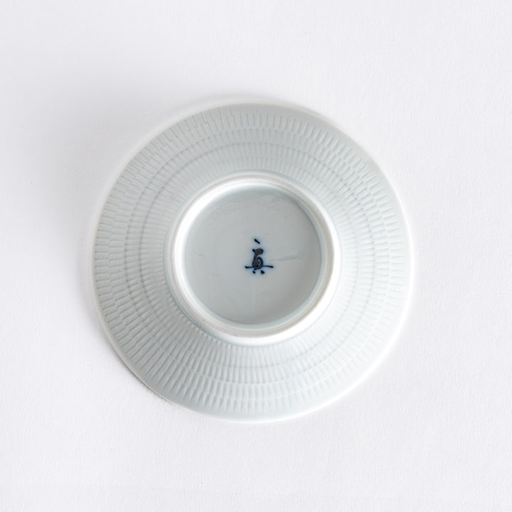 The bottom of the light blue dessert plate, featuring a smooth white base with a subtle rim.