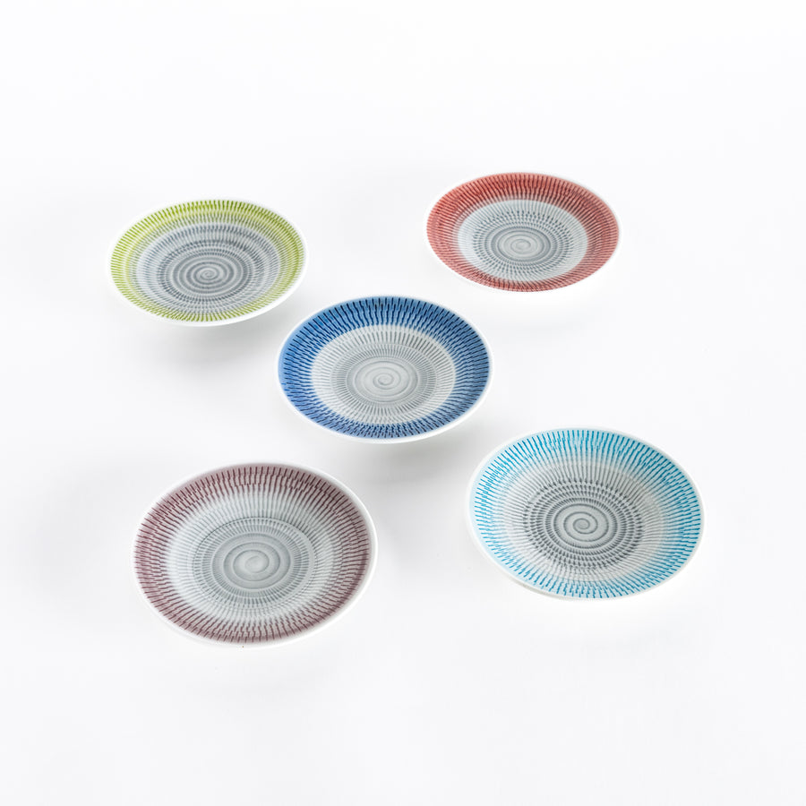 Five dessert plates with radiating striped patterns in blue, red, yellow, green, and light blue, arranged slightly tilted.