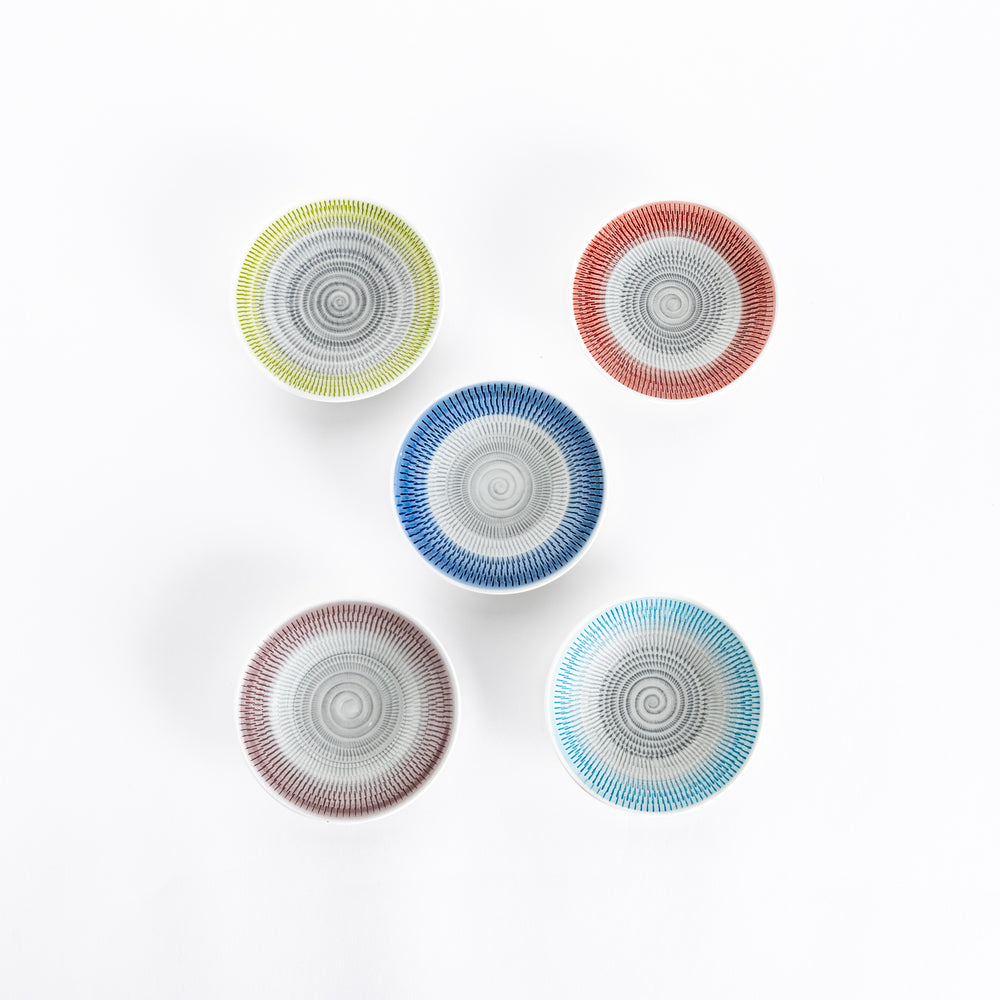 Five dessert plates viewed from above, showcasing spiral-striped patterns in blue, red, yellow, green, and light blue.