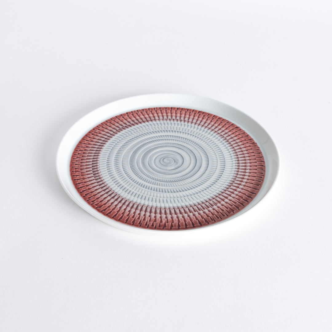 Slightly angled view of the plate, highlighting the red spiral pattern and subtle curvature.