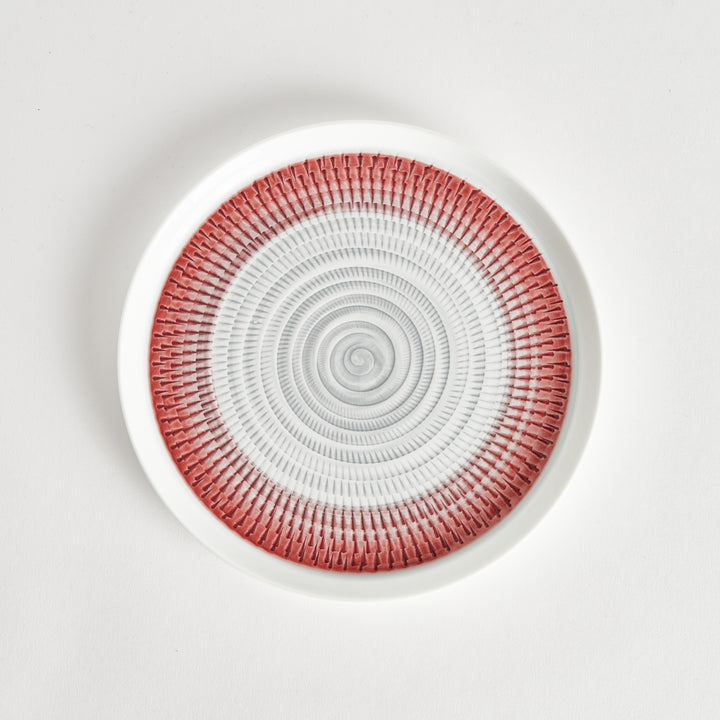 Top view of a plate featuring a red spiral pattern on a white background.