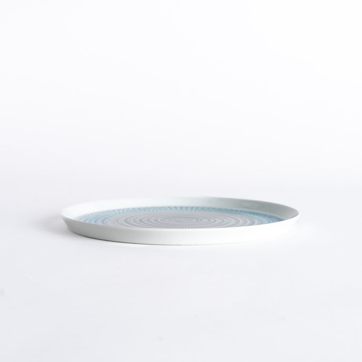 Side view of the plate, showcasing its sleek profile and the vibrant light blue spiral design.