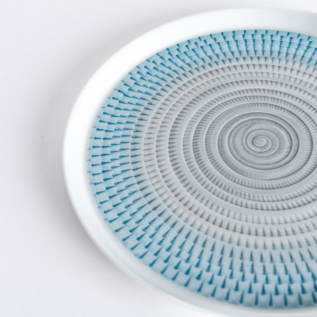 Close-up of the intricate light blue spiral pattern, radiating outwards with fine detail.