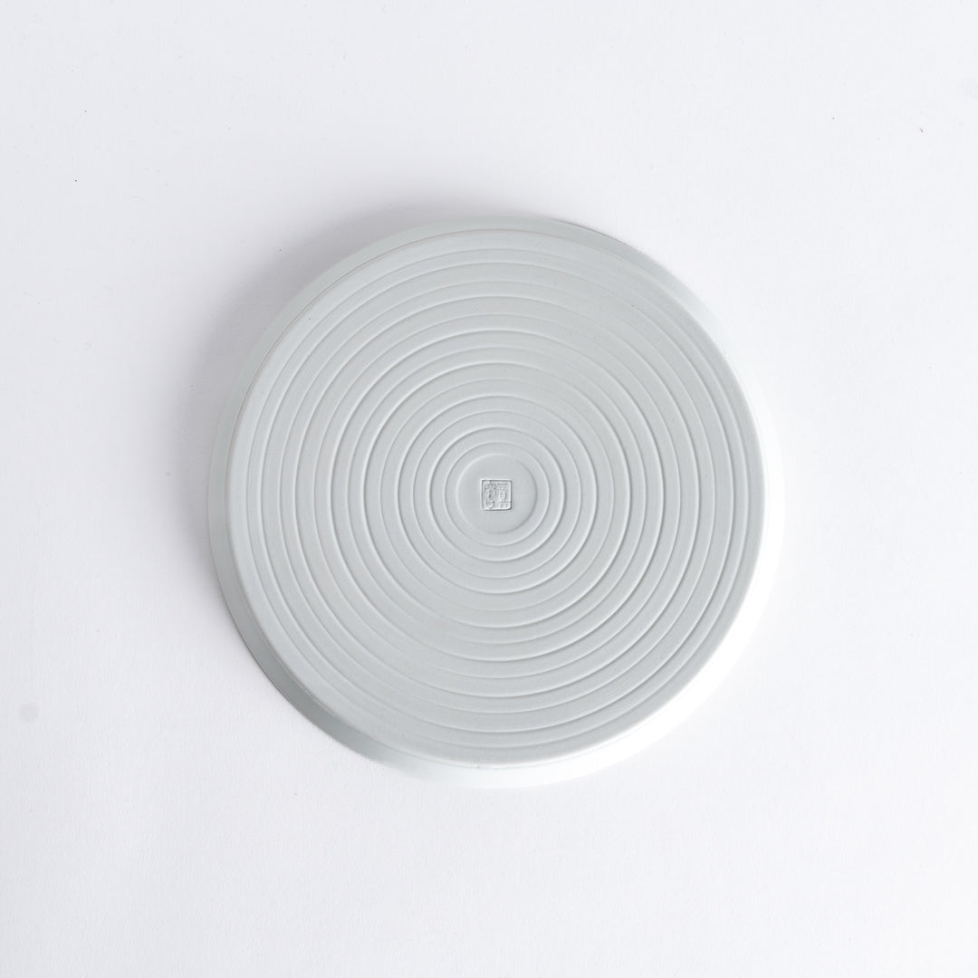 Bottom view of the plate, revealing a clean white surface with a small maker’s mark at the center.