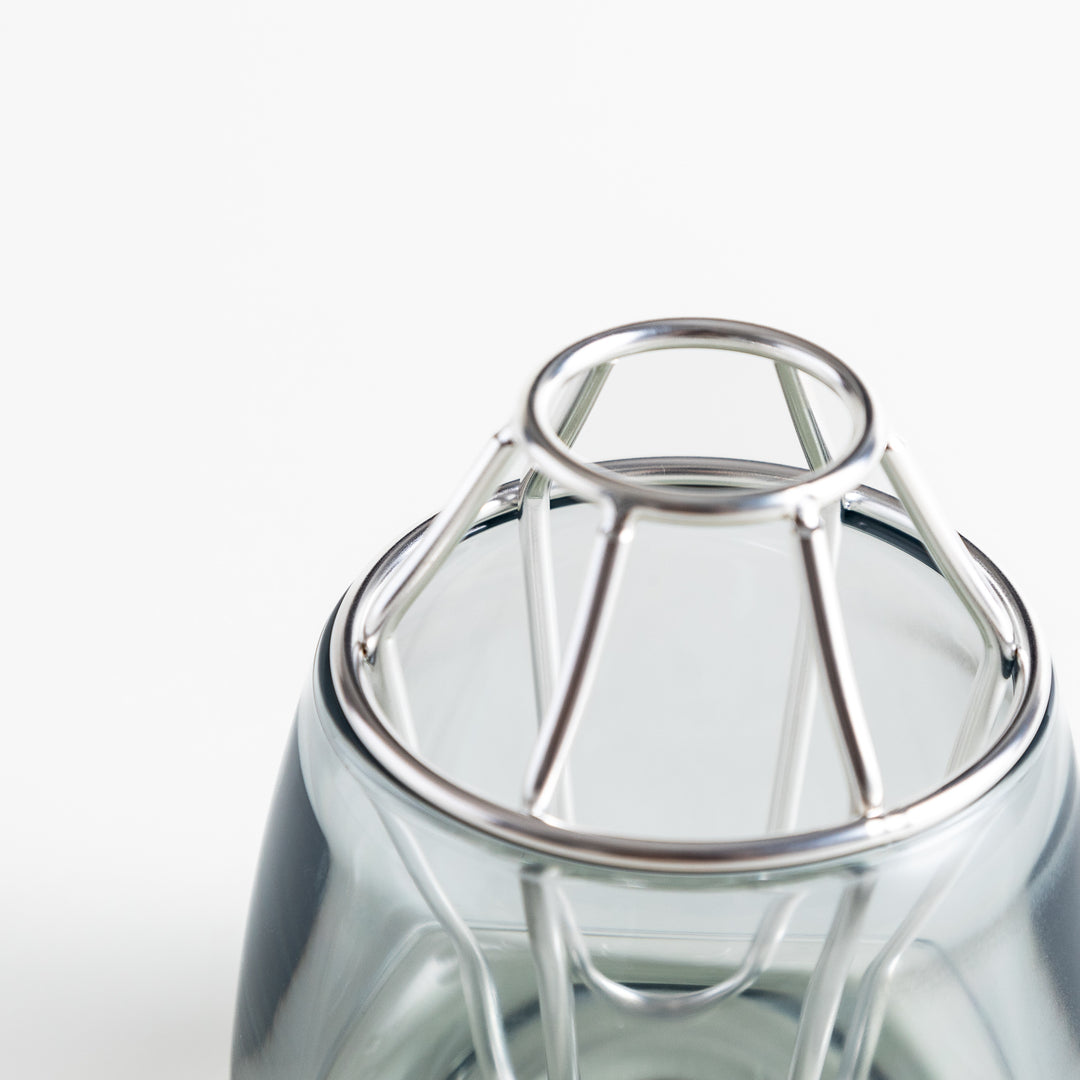 Close-up of the silver frame at the top of the glass vase, showing the intricate design and details.