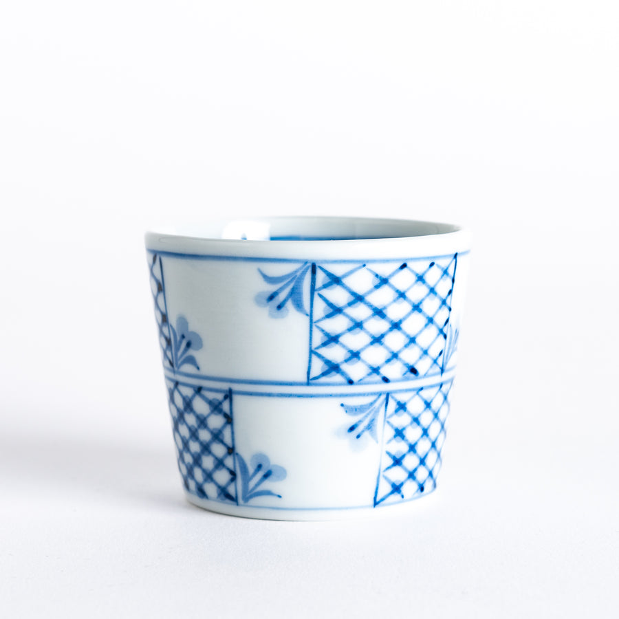 Elegant blue and white small condiment bowl with floral and checkered patterns, perfect for serving sauces.