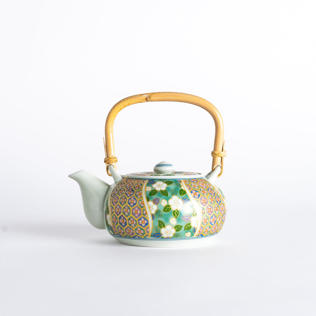 Side view of the teapot with bamboo handle and floral design on the body, showcasing the elegant curves.