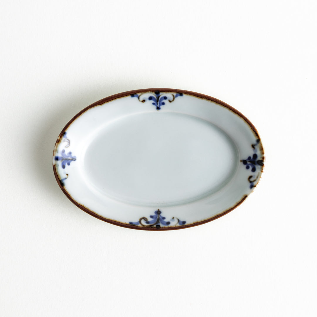 A single oval plate featuring a blue floral leaf design around the edges, showcasing its elegant shape and detailed decoration.