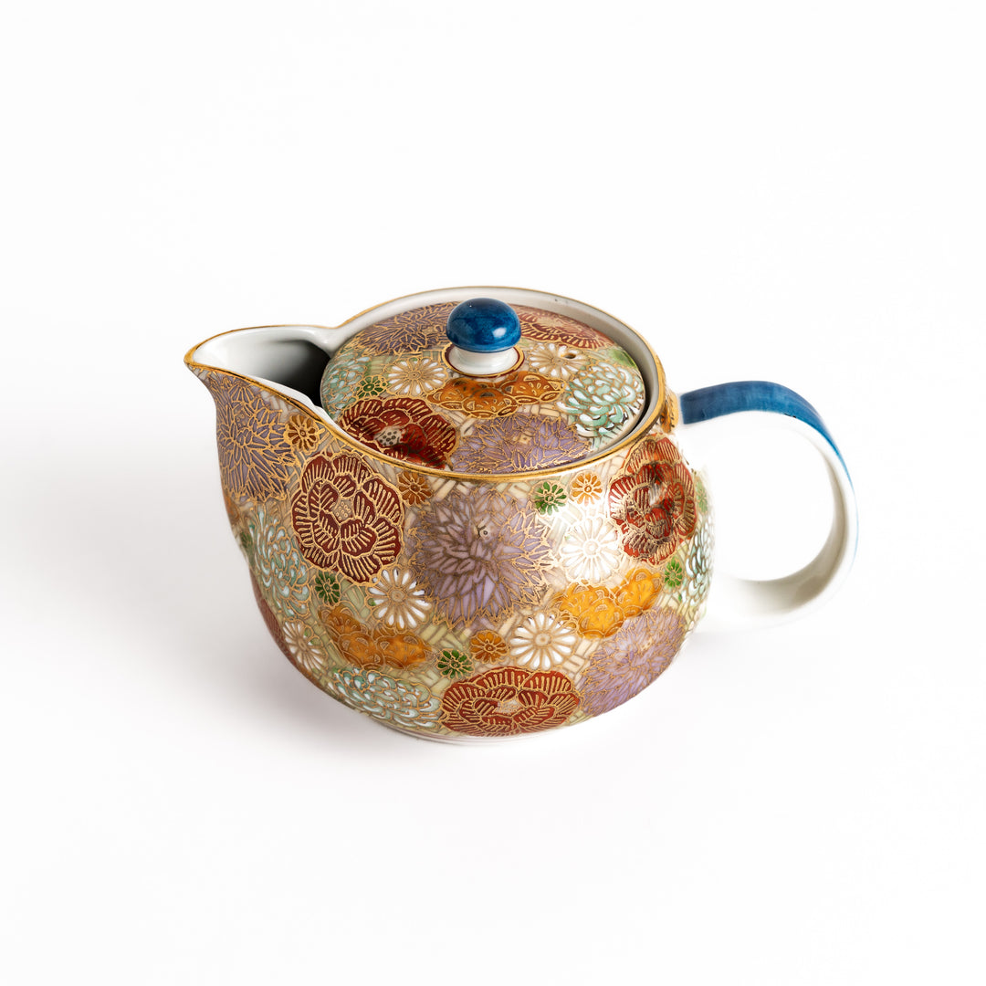 Ceramic teapot with a vibrant floral pattern in gold and pastel colors, featuring a classic design, ideal for brewing and serving tea.