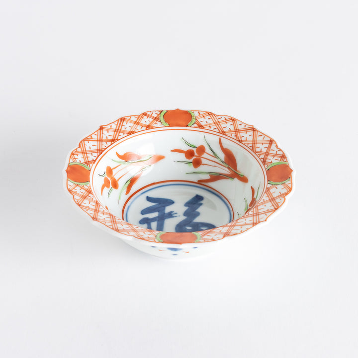 A dessert bowl with bold red and green designs around the rim, with a large blue kanji character in the center representing "fortune."