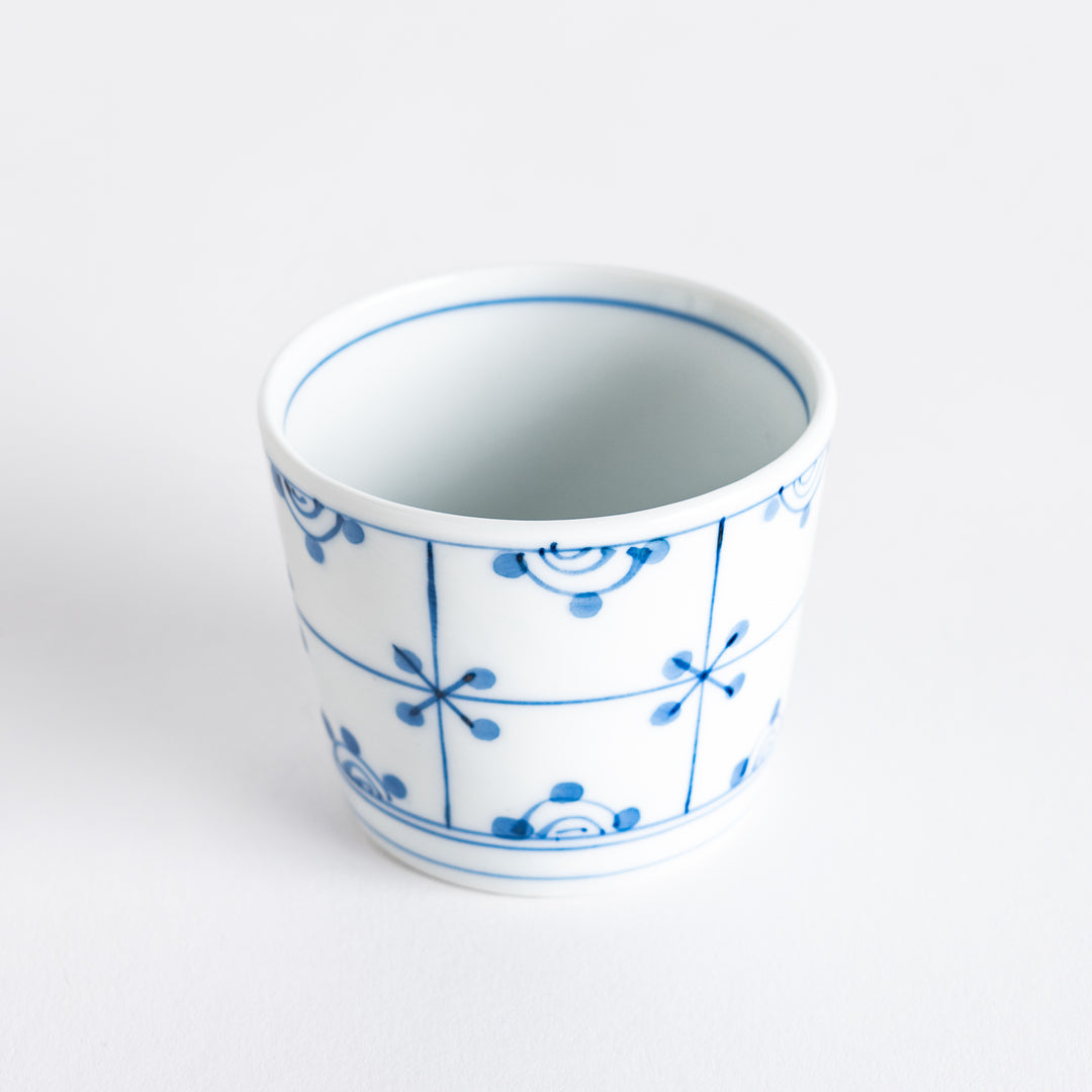 A small white condiment bowl with a delicate blue chrysanthemum and lattice pattern on the exterior.