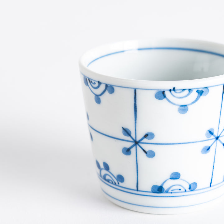 A small white condiment bowl with a delicate blue chrysanthemum and lattice pattern on the exterior.