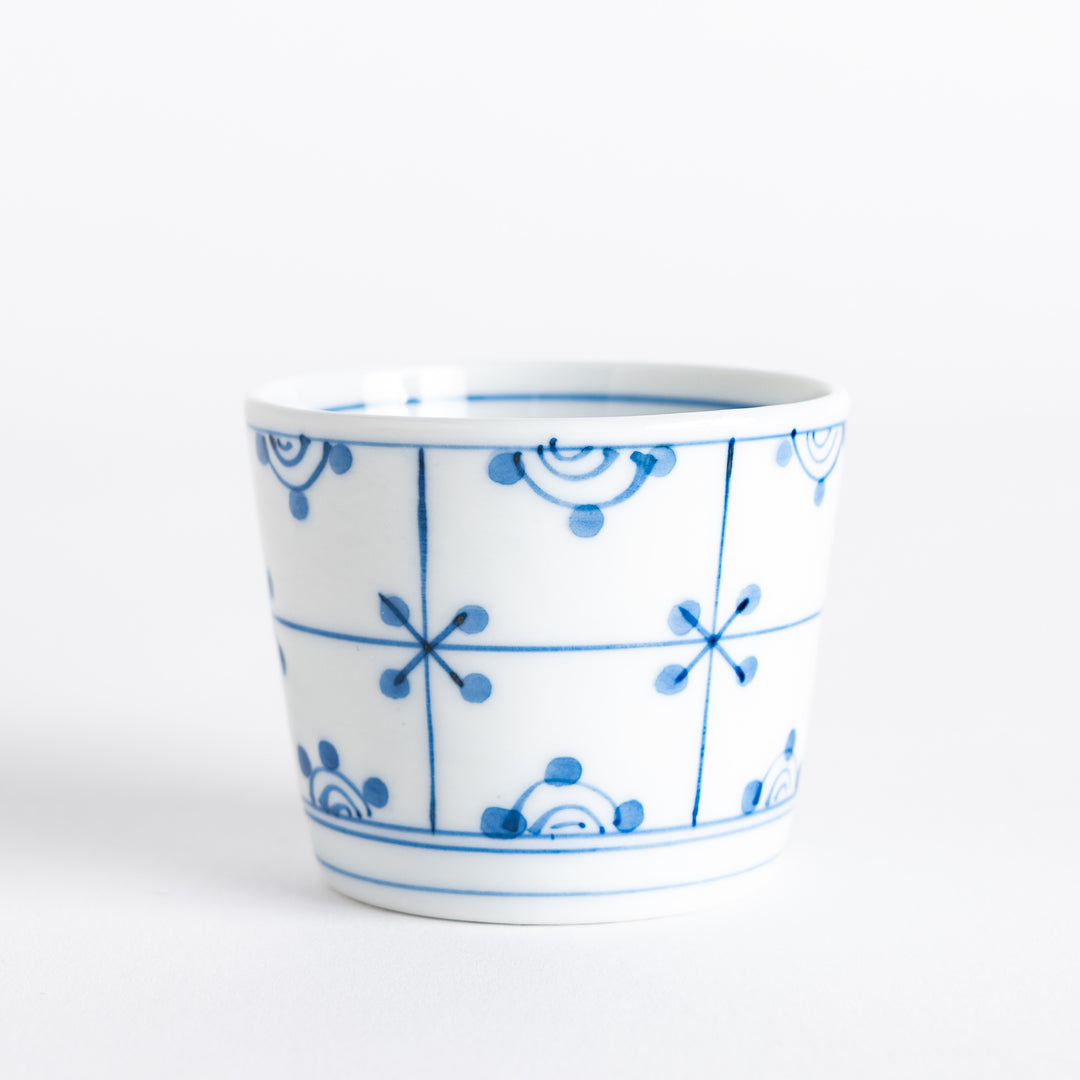 A small white condiment bowl with a delicate blue chrysanthemum and lattice pattern on the exterior.