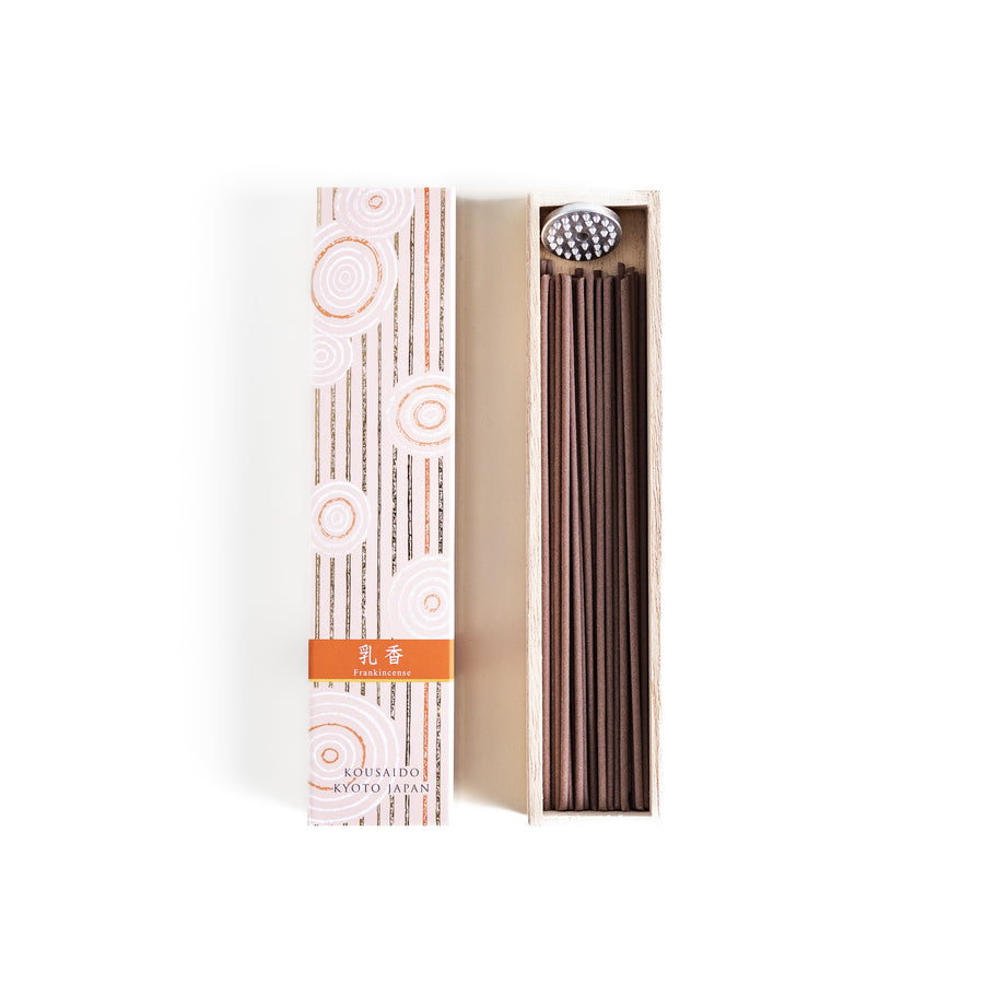 Frankincense Resin Incense in a light wooden box with earthy brown sticks, elegantly packaged in a soft beige design featuring white circular patterns, evoking a warm and spiritually uplifting aroma.