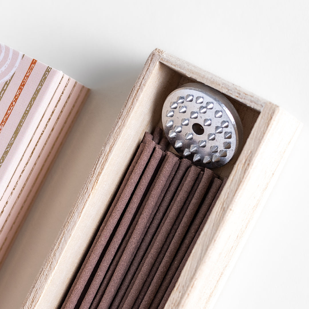 Frankincense Resin Incense in a light wooden box with earthy brown sticks, elegantly packaged in a soft beige design featuring white circular patterns, evoking a warm and spiritually uplifting aroma.