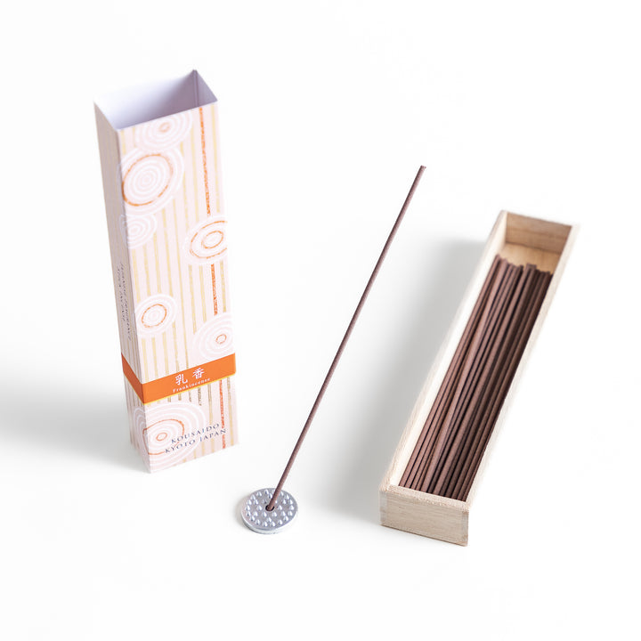 Frankincense Resin Incense in a light wooden box with earthy brown sticks, elegantly packaged in a soft beige design featuring white circular patterns, evoking a warm and spiritually uplifting aroma.