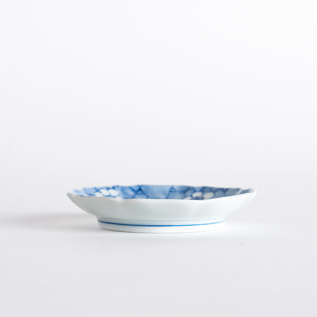 Side view of the round dish displaying its elegant curves, with a soft blue design and a refined finish on a white background.