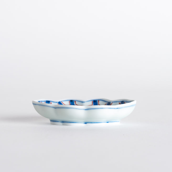 Low-angle view of a decorative sauce dish highlighting its detailed hexagonal design and unique shape.