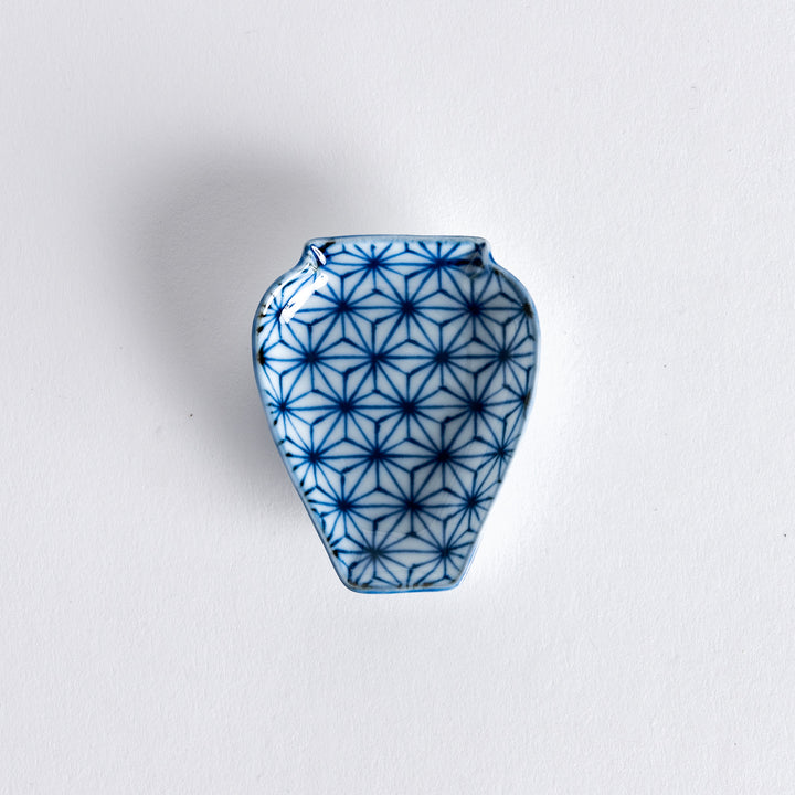 A small, vase-shaped dish featuring a blue geometric flower pattern, perfect for serving condiments or as a decorative piece.