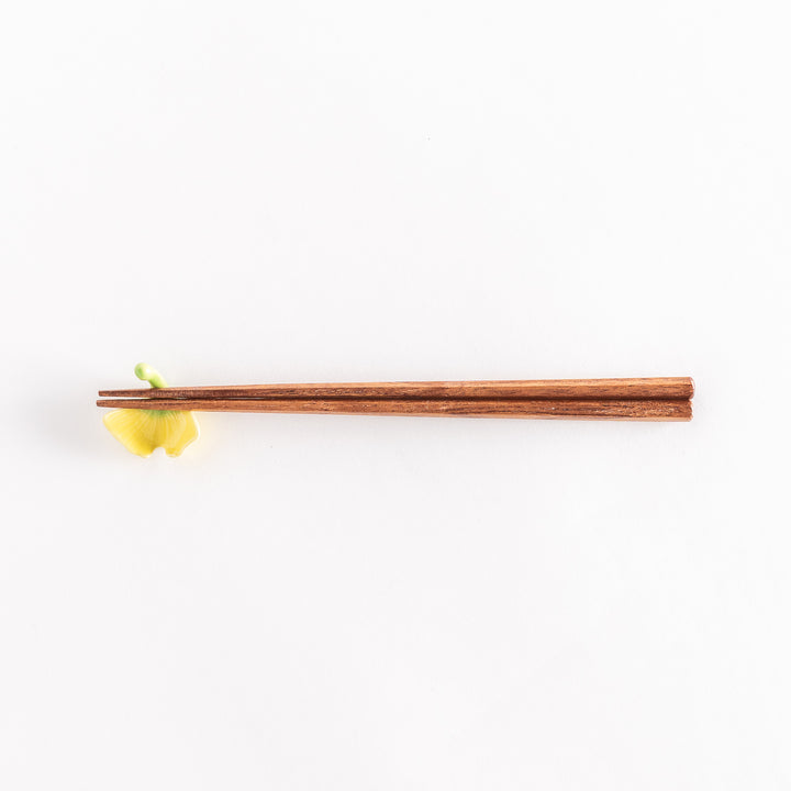 Chopsticks resting on the ginkgo leaf chopsticks rest, full view from above.