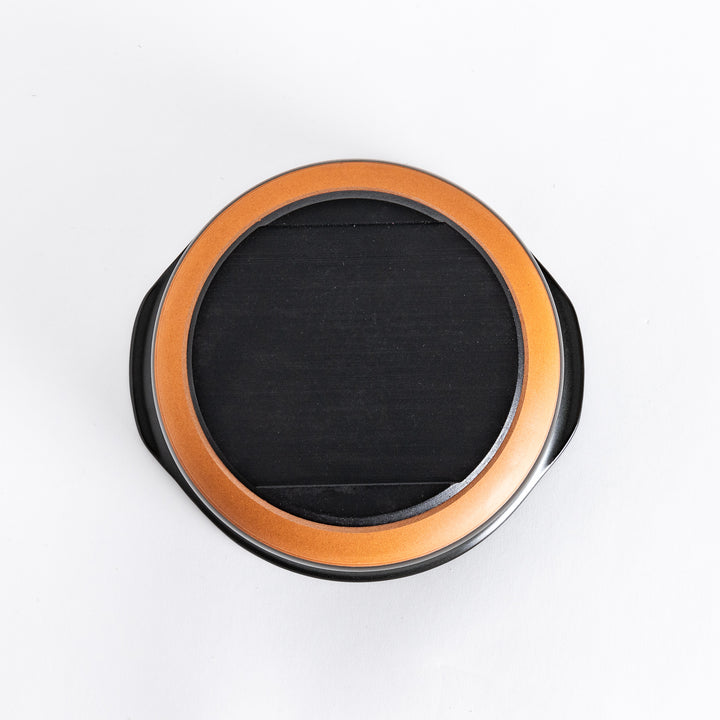 Bottom view of the donabe, showing its sturdy matte black base with a circular flat surface.