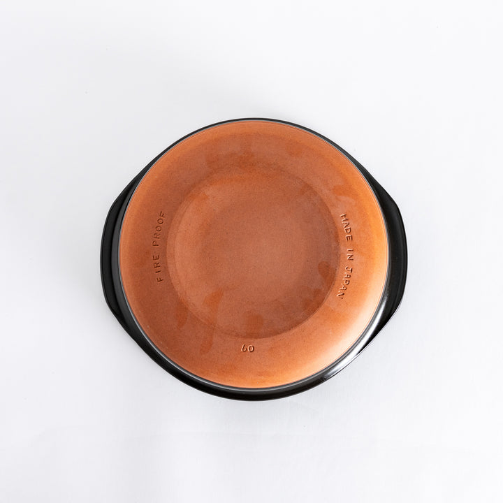 Bottom view of the donabe, featuring its smooth black surface with a stable circular base.